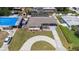 Beautiful aerial view of a home and yard with circular driveway and screened pool at 8006 N Ola Ave, Tampa, FL 33604