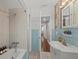 Bright bathroom features blue tile, a bathtub, and a vanity with a decorative mirror at 8006 N Ola Ave, Tampa, FL 33604