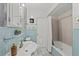 Bathroom features blue tile, a bathtub with shower, and a vanity with decorative mirror at 8006 N Ola Ave, Tampa, FL 33604