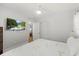 Bright bedroom featuring hardwood floors, a ceiling fan, and a wall-mounted television at 8006 N Ola Ave, Tampa, FL 33604