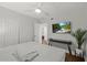 Bedroom featuring hardwood floors, a ceiling fan, and a wall-mounted television at 8006 N Ola Ave, Tampa, FL 33604