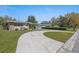 Long driveway leading to a well-manicured front yard with mature trees and landscaping at 8006 N Ola Ave, Tampa, FL 33604