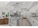 Well-lit, updated kitchen with white cabinets, tile backsplash, and open access to living space at 8006 N Ola Ave, Tampa, FL 33604