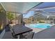 Covered patio with dining set, leading to a screened-in pool area at 8006 N Ola Ave, Tampa, FL 33604