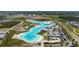 Aerial shot of the community's lagoon, white sandy beach, with homes and landscape around the perimeter at 8056 Rolling Shell Trl, Wesley Chapel, FL 33545