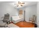 Bedroom featuring hardwood floors, a ceiling fan, and a cozy white sofa at 808 Alpine Thistle Dr, Brooksville, FL 34604