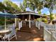 Outdoor brick bar area with seating, surrounded by a white fence on a wood deck, and lush landscaping at 8647 Mallard Reserve Dr # 104, Tampa, FL 33614