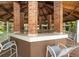 Interior view of the outdoor brick bar area with tile countertop, seating, and wood ceiling at 8647 Mallard Reserve Dr # 104, Tampa, FL 33614
