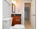 Bathroom with dark vanity and mirror with view to a hallway at 8647 Mallard Reserve Dr # 104, Tampa, FL 33614