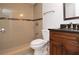 Bathroom featuring tiled walk-in shower, dark vanity, and white toilet at 8647 Mallard Reserve Dr # 104, Tampa, FL 33614