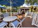 Community pool area with tables, chairs, umbrellas, and bar area surrounded by a white fence on a wood deck at 8647 Mallard Reserve Dr # 104, Tampa, FL 33614