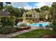 Community pool surrounded by lounge chairs and lush landscaping under a bright blue sky at 8647 Mallard Reserve Dr # 104, Tampa, FL 33614