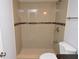 Walk-in shower featuring tile surround with decorative accent, shower head, and handheld shower at 8647 Mallard Reserve Dr # 104, Tampa, FL 33614