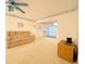 Bright living room with a tan sofa, light carpet, and easy access to a patio through sliding glass doors at 946 Virgina # 304, Dunedin, FL 34698