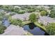 Aerial view of the property showcasing the building, pond, landscaping, and surrounding greenery at 10205 Courtney Palms Blvd # 304, Tampa, FL 33619