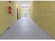 Hallway with concrete floors and yellow stucco-style walls, leading to an outdoor gated area at 10205 Courtney Palms Blvd # 304, Tampa, FL 33619