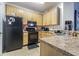 Well-lit kitchen featuring wooden cabinets, granite countertops, and stainless steel appliances at 10205 Courtney Palms Blvd # 304, Tampa, FL 33619