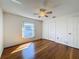 Bedroom featuring hardwood floors, ceiling fan, and closet space at 1042 Trafalgar Dr, New Port Richey, FL 34655