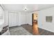 Spacious bedroom featuring wood-look floors, dual closets, and view into dining area at 11338 Yellowwood Ln, Port Richey, FL 34668