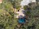 Overhead view of a home with a screened-in pool, shaded by mature trees for ultimate privacy at 12005 Wren Ct, New Port Richey, FL 34654