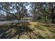 Spacious back yard with mature trees, a white fence, and a glimpse of the charming home at 12005 Wren Ct, New Port Richey, FL 34654