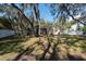 A view of the lush green backyard with mature trees and a screened pool at 12005 Wren Ct, New Port Richey, FL 34654