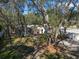 View of a home and screen enclosed pool, nestled in a tree filled backyard at 12005 Wren Ct, New Port Richey, FL 34654