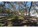 Large backyard is surrounded by mature trees and has a white fence at 12005 Wren Ct, New Port Richey, FL 34654