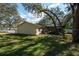 Expansive backyard with lush green grass, mature trees, and a screened pool area, perfect for outdoor entertaining at 12005 Wren Ct, New Port Richey, FL 34654