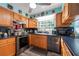 View of the kitchen, featuring wood cabinets, stainless appliances, and blue countertops at 12005 Wren Ct, New Port Richey, FL 34654