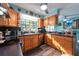 View of the kitchen with wooden cabinets, stainless appliances, and access to the dining area at 12005 Wren Ct, New Port Richey, FL 34654