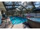A backyard pool and hot tub are surrounded by a screened enclosure with patio seating at 12005 Wren Ct, New Port Richey, FL 34654