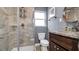 Bathroom featuring granite countertop vanity, shower with glass doors and a circular mirror at 1316 W Hiawatha St, Tampa, FL 33604