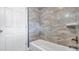 Bathroom featuring a white tiled tub shower and a white door at 1316 W Hiawatha St, Tampa, FL 33604