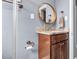 Bathroom vanity with granite countertop, circular mirror, and bronze hardware with shower at 1316 W Hiawatha St, Tampa, FL 33604
