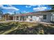 Rear exterior view of home featuring covered patio with ample yard space enclosed by a white fence at 1316 W Hiawatha St, Tampa, FL 33604