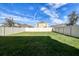 Spacious, well-manicured backyard enclosed by a white privacy fence and mature trees at 16849 Trite Bend St, Wimauma, FL 33598