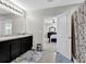 Bright bathroom with double vanity sink and tiled floors adjoins the Primary bedroom at 16849 Trite Bend St, Wimauma, FL 33598