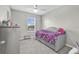 Cozy bedroom features a ceiling fan, a window with blinds, and plush carpeting at 16849 Trite Bend St, Wimauma, FL 33598