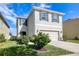 Charming two-story home with gray shutters, a well-manicured lawn, and an attached two-car garage at 16849 Trite Bend St, Wimauma, FL 33598