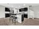 Modern kitchen with dark cabinets, granite countertops, and stainless steel appliances at 16849 Trite Bend St, Wimauma, FL 33598