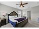 Bright main bedroom featuring a dark-wood bed frame and ceiling fan at 16849 Trite Bend St, Wimauma, FL 33598