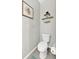 Cozy powder room featuring tiled floors, floating shelves and decorative artwork at 16849 Trite Bend St, Wimauma, FL 33598