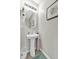 Charming powder room featuring a pedestal sink, decorative mirror and tiled floor at 16849 Trite Bend St, Wimauma, FL 33598