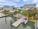 Aerial view of waterfront homes featuring a pool, private dock, boat and manicured landscaping at 17404 1St E St, Redington Shores, FL 33708