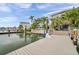 A beautiful backyard, dock and waterfront view showcasing lush landscaping and a private boat dock at 17404 1St E St, Redington Shores, FL 33708