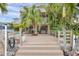 A beautiful backyard with lush landscaping overlooks a wooden deck, canal and outdoor seating area at 17404 1St E St, Redington Shores, FL 33708