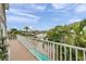 Balcony view overlooking the pool, canal, and neighboring properties with swaying palm trees at 17404 1St E St, Redington Shores, FL 33708