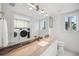Modern bathroom featuring a stylish vanity with marble countertop, and adjacent laundry machines at 17404 1St E St, Redington Shores, FL 33708