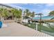 A backyard boat dock features a boat lift with access to waterfront and neighborhood views at 17404 1St E St, Redington Shores, FL 33708